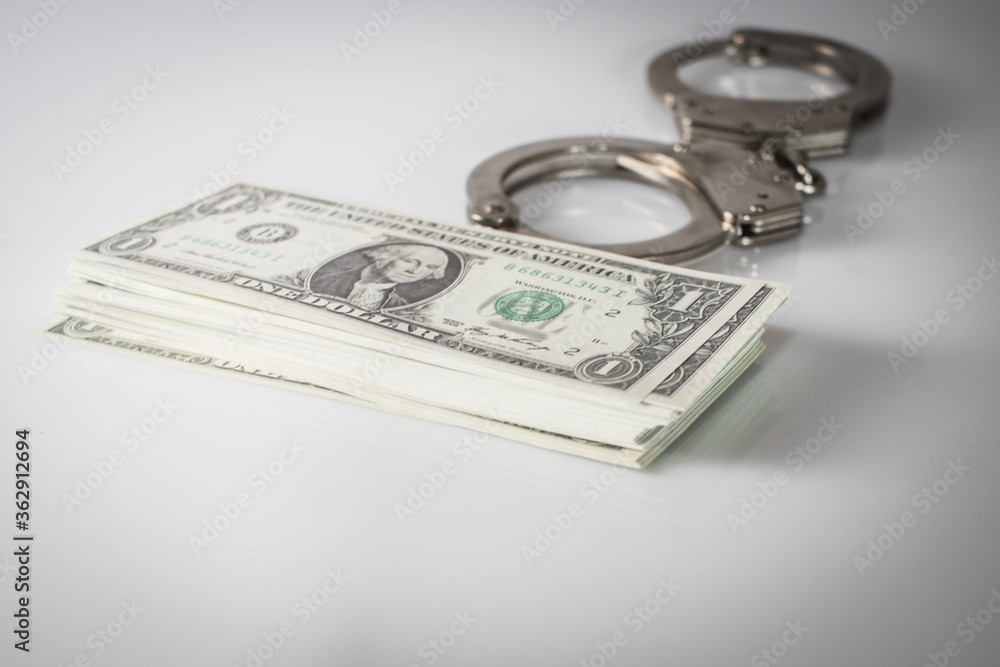 Handcuff above usa dollar. Theft, background Handcuff above usa dollar. Theft, background