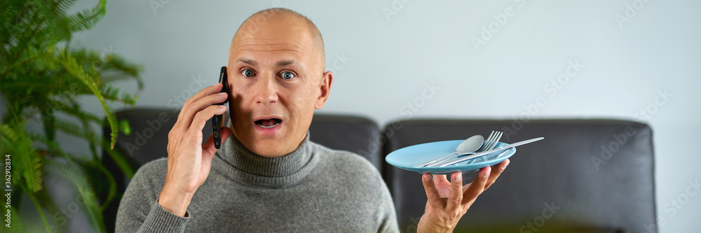 Man talking on mobile phone at sofa.Home food order concept. Man talking on mobile phone at sofa.Home food order concept.