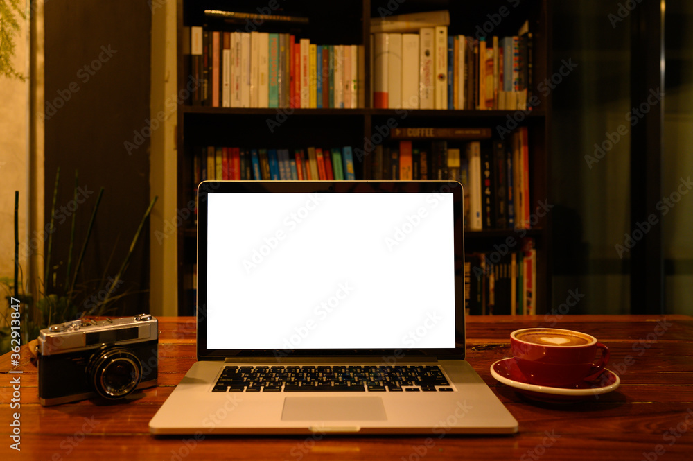 Blank screen of Laptop computer with film camera and coffee cup on wooden table Blank screen of Laptop computer with film camera and coffee cup on wooden table