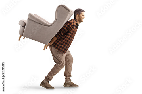 Photography Young man carrying an armchair on his back
