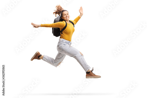 Female student with a backpack jumping high