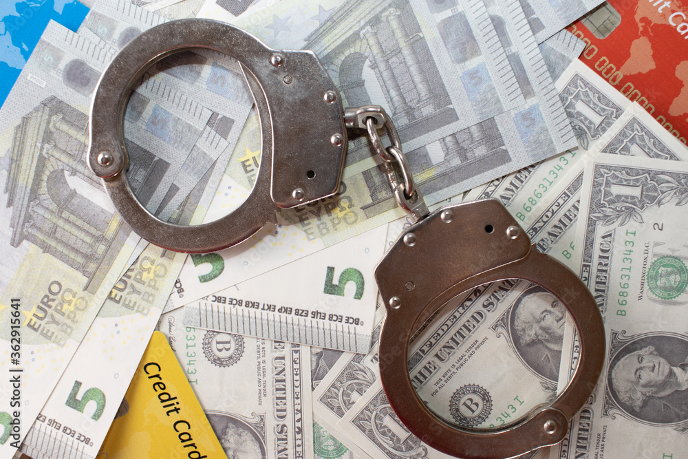 Dollar ,euro , credit cards and police handcuffs on a white background Dollar ,euro , credit cards and police handcuffs on a white background