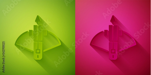 Paper cut Battle crossbow with arrow icon isolated on green and pink background. Paper art style. Vector.