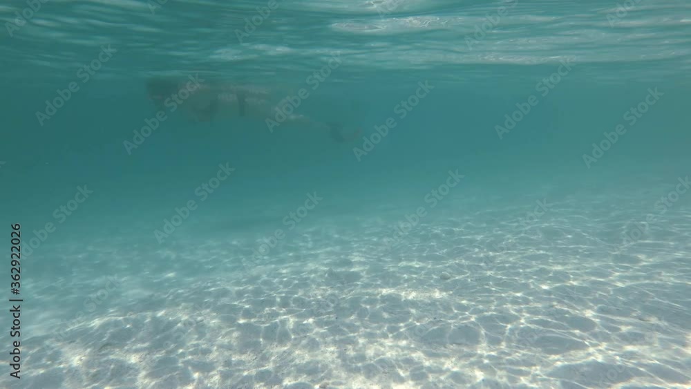 Slow motion. Water movement in the ocean and reflection of sunlight. Swimmer movement in the background. 4K Slow motion. Water movement in the ocean and reflection of sunlight. Swimmer movement in the background. 4K