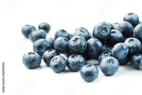 Tasty blueberries fruit are scattered on a white background.