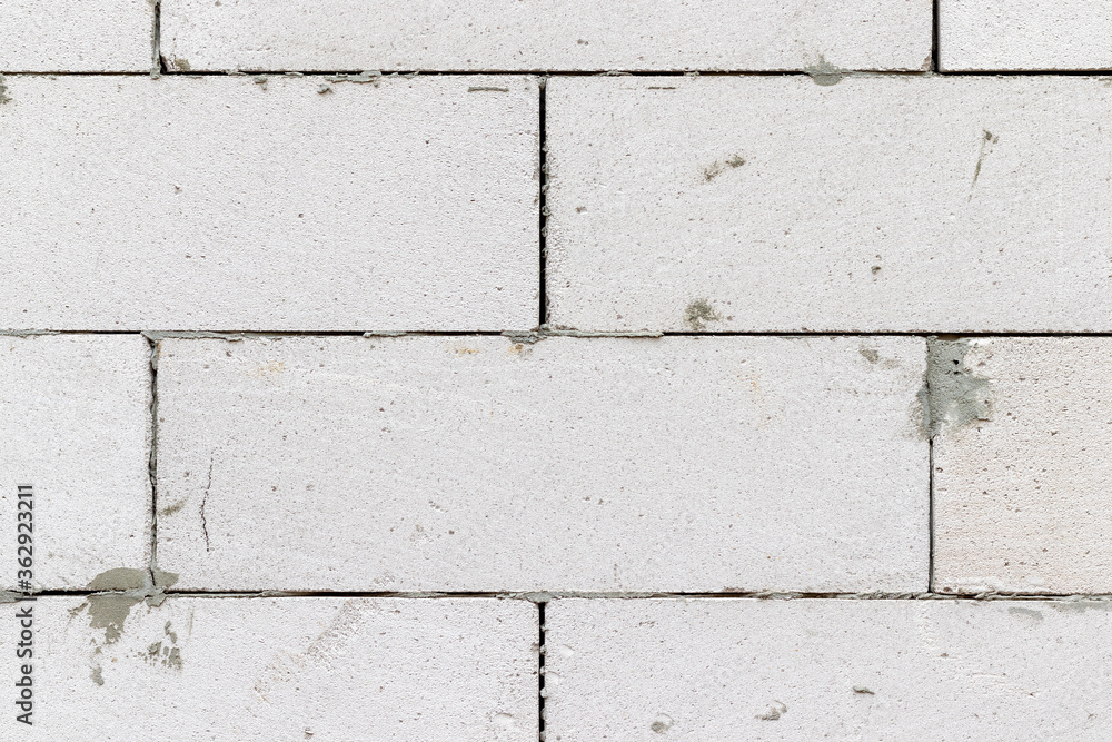 Fototapeta premium Smooth white brick wall with traces of cement background texture