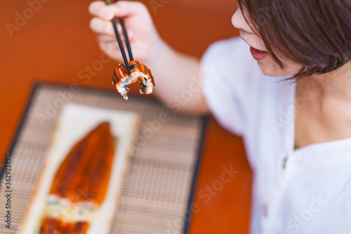 Japanese middle aged woman eats grilled Unagi photo