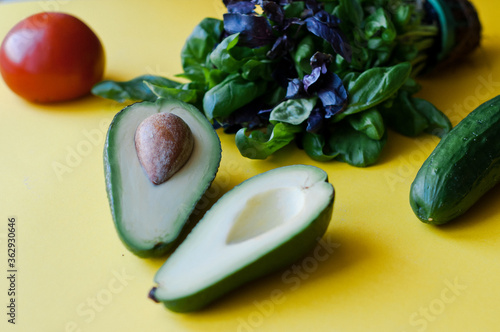 Fresh lettuce, avocado in a small pot. Green leaves on a yellow background. Flat lay. Eco food. Place for text photo