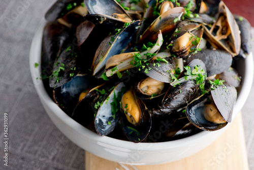 Mussels. Classic French or American restaurant appetizer: steamed mussels. Shellfish steamed with white wine, butter, garlic, onions and fresh herbs. Served with butter toasted baguettes.