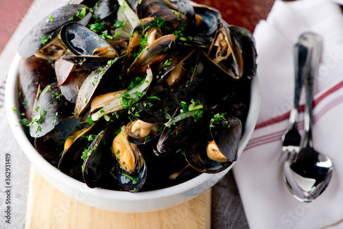 Mussels. Classic French or American restaurant appetizer: steamed mussels. Shellfish steamed with white wine, butter, garlic, onions and fresh herbs. Served with butter toasted baguettes.