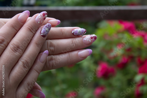  Ready beautiful manicure for a woman. Painted pink flowers. Concept of doing manicure. beauty concept. Gel polish, shellac. High quality photo