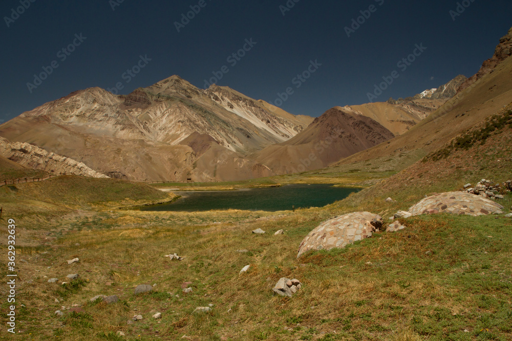 The valley and meadow. Turquoise color water lake at the foot of the mountains.