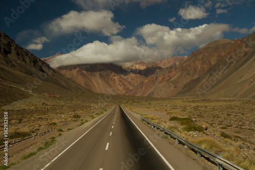 Transport. Traveling along the desert highway. Asphalt straight road into the arid mountains and valley. 