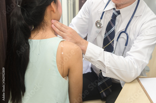 Medical doctor is examining glands in the neck of his patient.