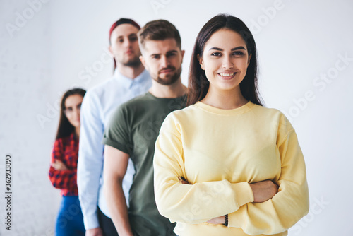 Portrait of smiling female team leader feeling confidence with coworkers standing on isolated background in office,dream team of business company collaborating under leadership of professional coach