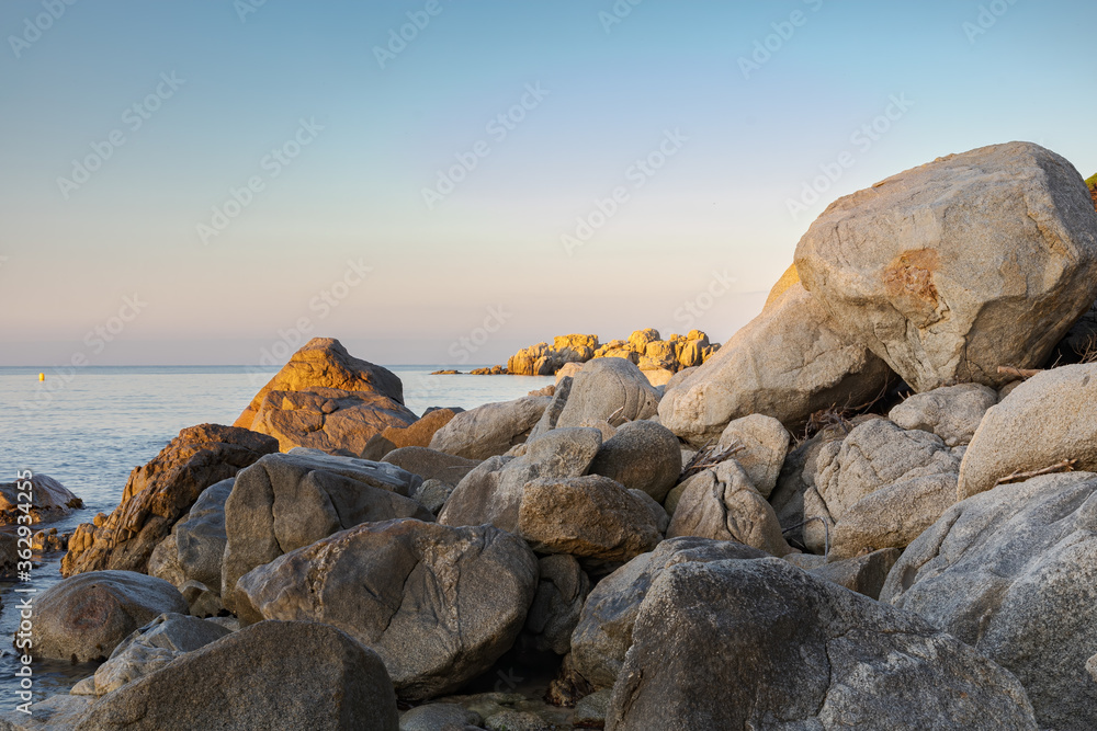 View of rocks sunlit by sunrise at the cliffs of the Costa Brava, Catalonia, Spain