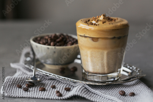 Dalgona whipped coffee, instant, cream, iced coffee. Cocktail with coffee, milk and ice cubes on grey background mockup. Trendy drink background with copy space for text.