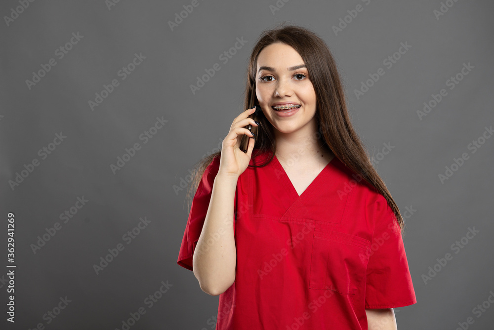 Attractive nurse with braces talking on her mobile phone to a patient Attractive nurse with braces talking on her mobile phone to a patient