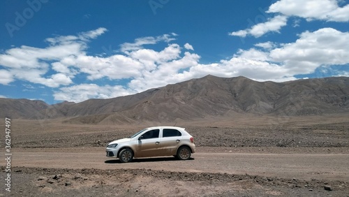 Car positioned in front of the mountains in the desert 