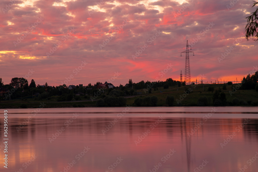 A bright red sunset over the lake is reflected in the water.