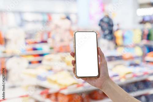 Mockup, hands holding blank white screen mobile phone in blurred department store, digital payment concept