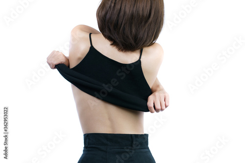 Quadro em tela woman taking off her black shirt, back view. White background.