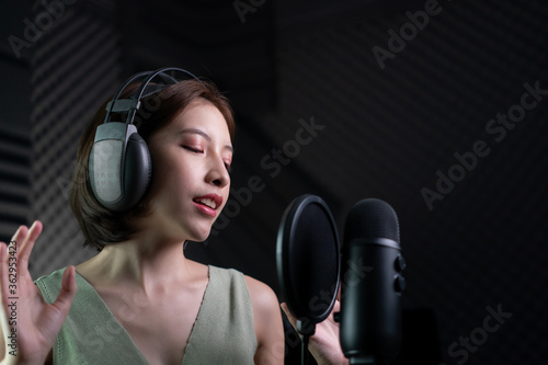 Woman recording a song or storytelling in the studio.