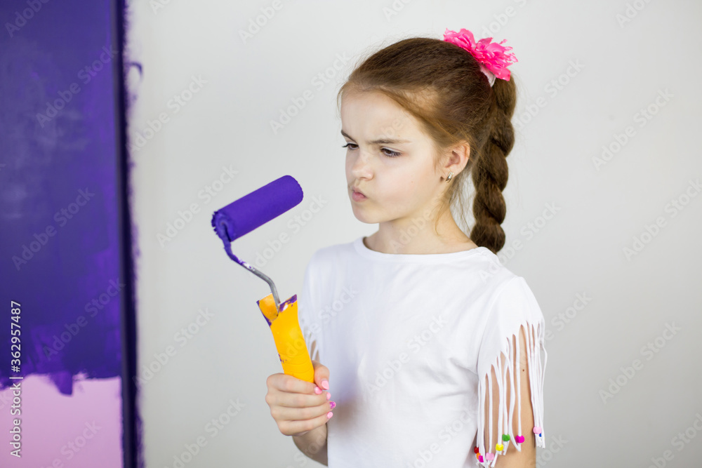 Little girl painting wall in room Little girl painting wall in room