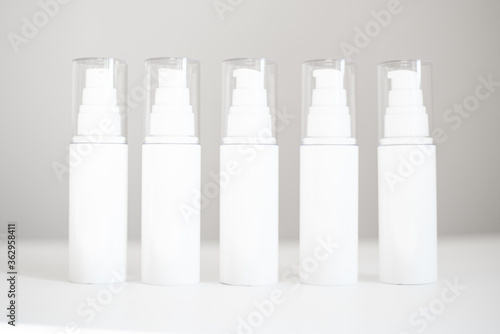 white bottles with dispenser stand on a white background. Natural Organic Spa Cosmetic Beauty Concept. Mockup Front view.