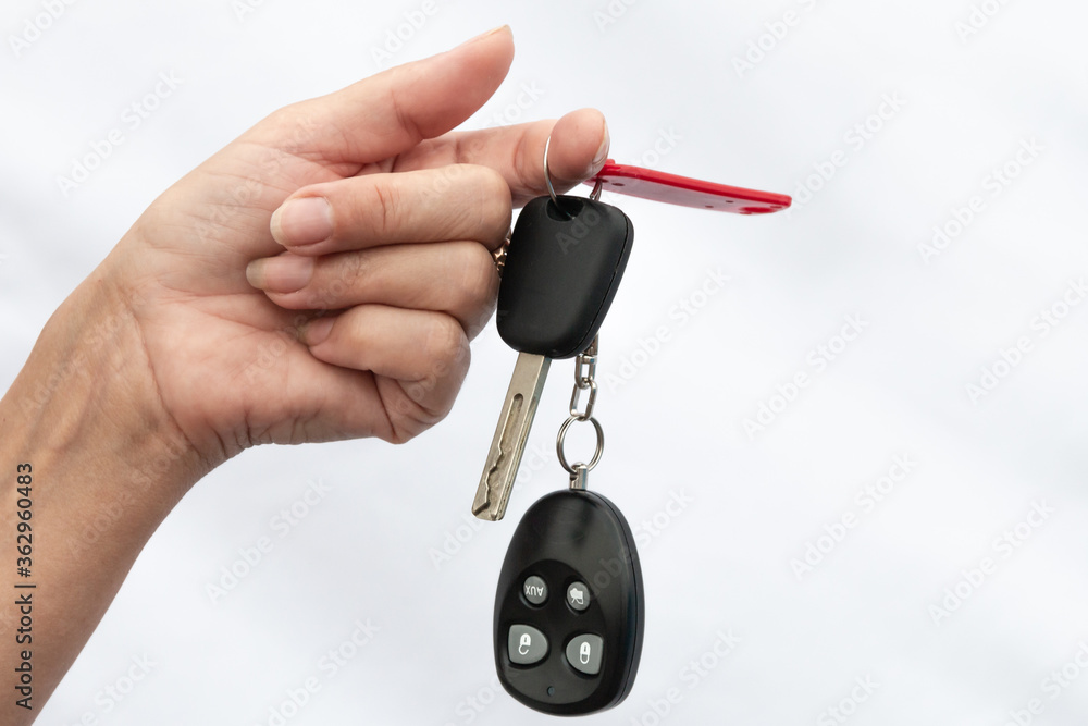 female hand holds car keys with alarm. close-up. White background.