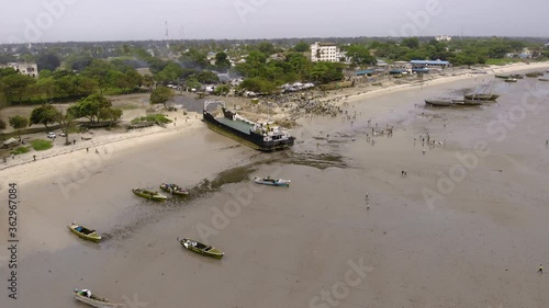 An aerial Flyby shot of Crowd of African people on a Low Tide at the Beach of Bagamoyo, Tanzania photo