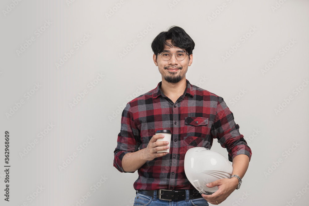 Portrait engineer holding coffee cup and safety helmet in studio. Isolated Asian man have mustache smiling in studio. Portrait engineer holding coffee cup and safety helmet in studio. Isolated Asian man have mustache smiling in studio.