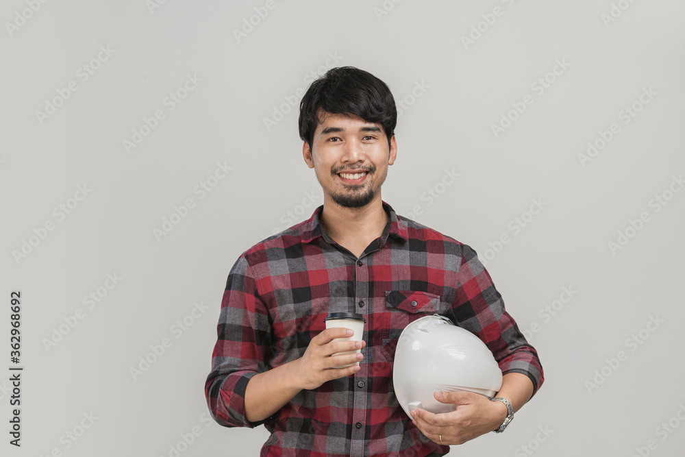 Portrait engineer holding coffee cup and safety helmet in studio. Isolated Asian man have mustache smiling in studio. Portrait engineer holding coffee cup and safety helmet in studio. Isolated Asian man have mustache smiling in studio.