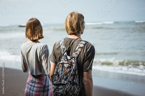 Young couple enjoy a trip together on the beach in the bright sunny day photo