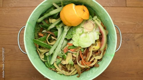 Throwing fruit and vegetable peels to a bin full of organic waste