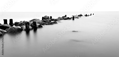 Breakwater Stones in the ocean dark mood for postcards about grief mourning or peaceful and soothing meditation and relaxation photo