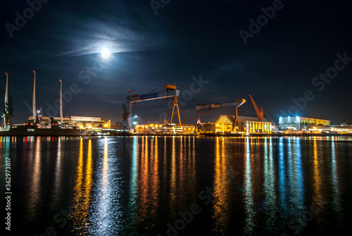 Container Harbor in Kiel Germany for freight transport and shipping of trade exports illuminated at night with bright moon