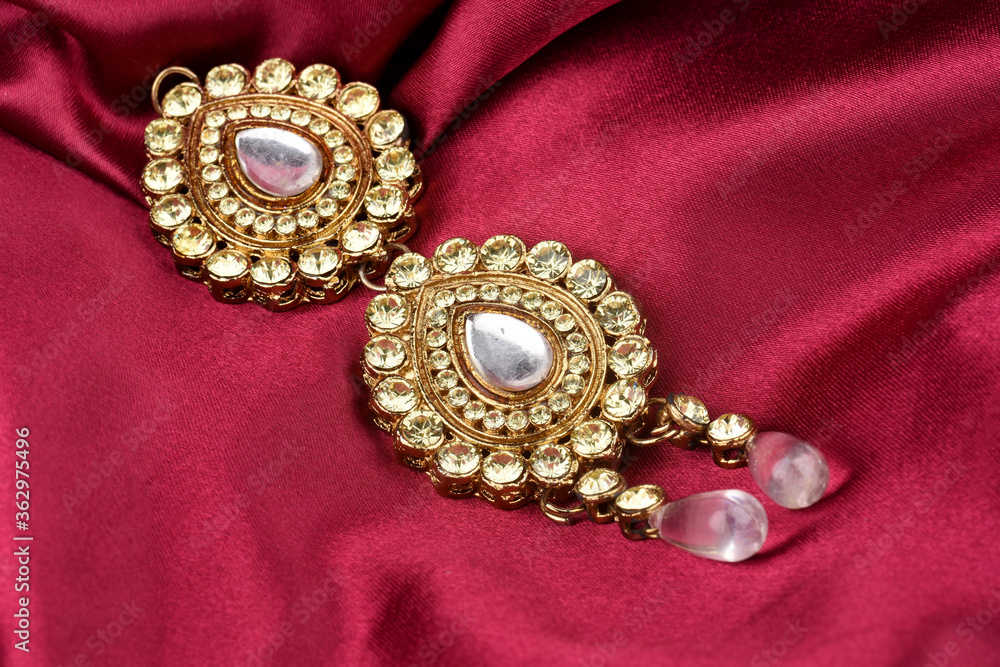 Kundan jewelry placed on red satin background. kundan and diamond pendant,Luxury female jewelry, Indian traditional jewellery, Bridal Gold wedding jewellery Kundan jewelry placed on red satin background. kundan and diamond pendant,Luxury female jewelry, Indian traditional jewellery, Bridal Gold wedding jewellery