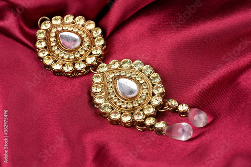 Kundan jewelry placed on red satin background. kundan and diamond pendant,Luxury female jewelry, Indian traditional jewellery, Bridal Gold wedding jewellery