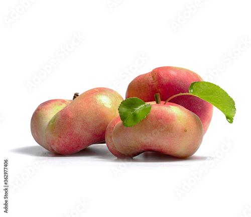 ripe and juicy peaches on a branch with leaves on a white background