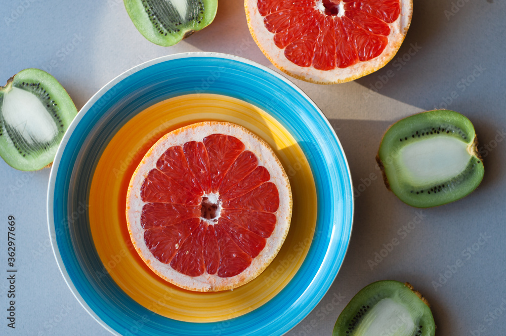 Top view of organic tropical fruits on palm leaves, Citrus slices orange and grapefruit with juice on gray background Top view of organic tropical fruits on palm leaves, Citrus slices orange and grapefruit with juice on gray background