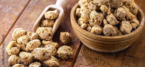 vegan food, coarse soy protein, also called soy meat, the protein textured in pieces inside a wooden bowl photo