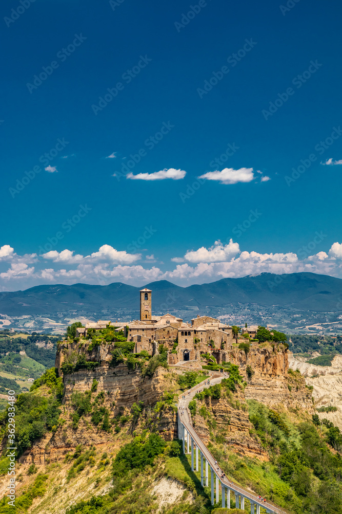 View of the medieval town of Civita di Bagnoregio, located on the top of a spur of tuff rock, in the middle of the valley of the badlands. Connected to the city by a small bridge, mule track.
