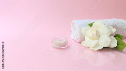 Spa setting and Spa background composition with white gardenia flower on pink background. Banner