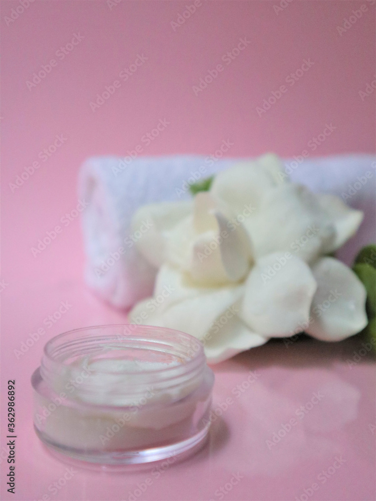 Spa setting and Spa background composition with white gardenia flower on pink background. vertical photo