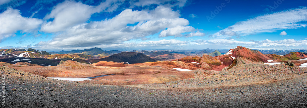 Panoramic true Icelandic landscape view of colorful rainbow volcanic Landmannalaugar mountains, volcanoes, valleys and famous Laugavegur hiking trail at blue sky, Iceland, summer
