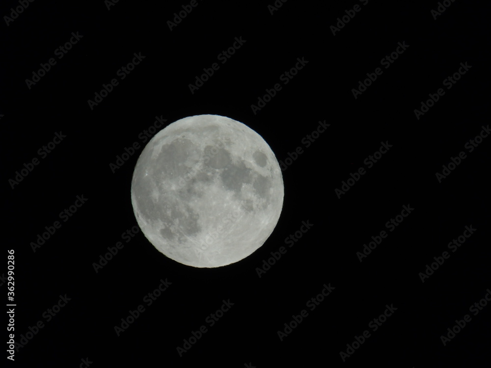 Genova, Italy - 07/05/2020: An amazing photography of the full moon over the city of Genova by night with a great clear and blue sky in the background and some stars. Genova, Italy - 07/05/2020: An amazing photography of the full moon over the city of Genova by night with a great clear and blue sky in the background and some stars.