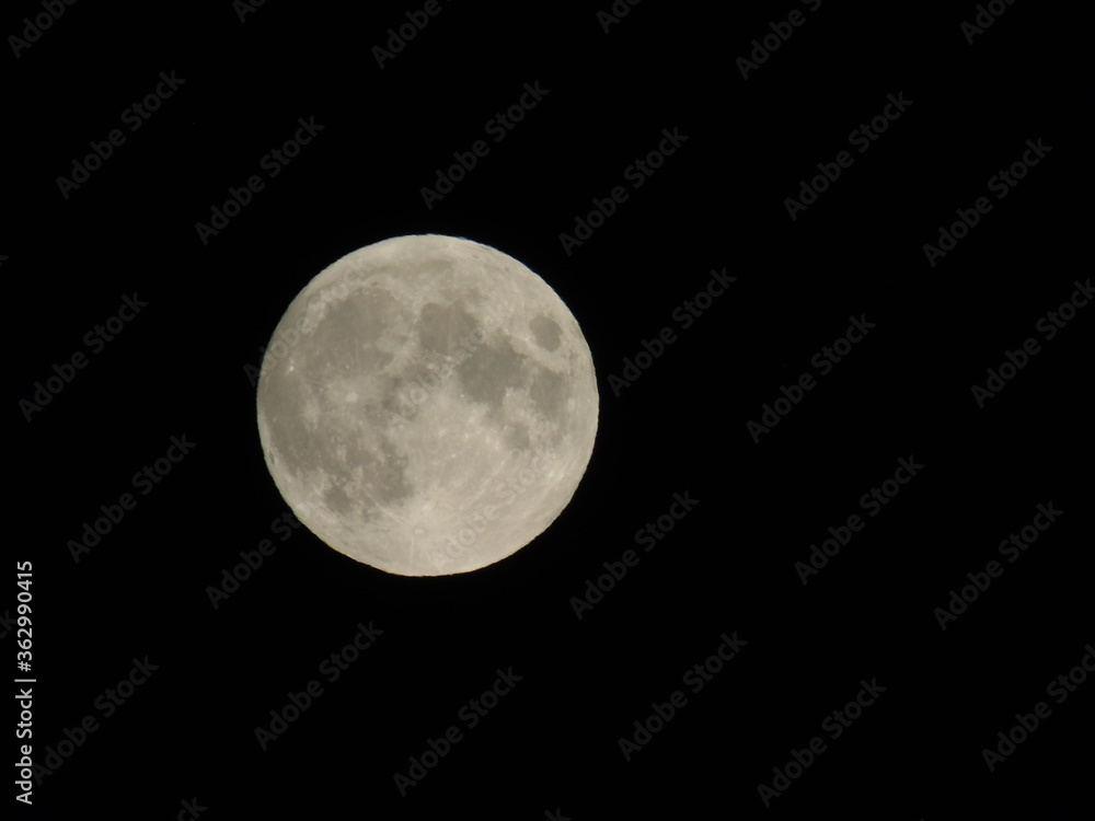 Genova, Italy - 07/05/2020: An amazing photography of the full moon over the city of Genova by night with a great clear and blue sky in the background and some stars. Genova, Italy - 07/05/2020: An amazing photography of the full moon over the city of Genova by night with a great clear and blue sky in the background and some stars.