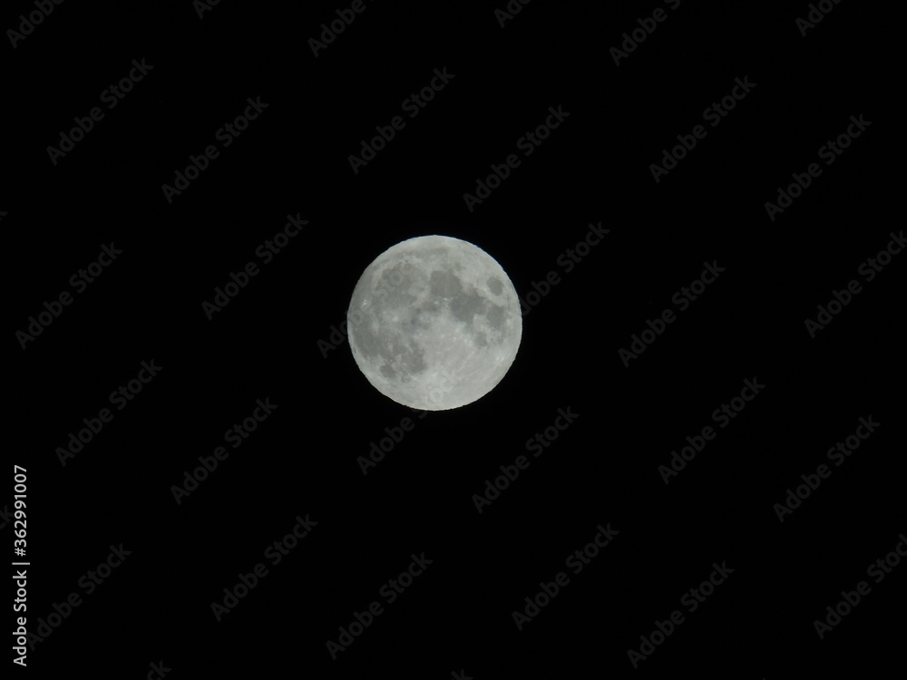 Genova, Italy - 07/05/2020: An amazing photography of the full moon over the city of Genova by night with a great clear and blue sky in the background and some stars. Genova, Italy - 07/05/2020: An amazing photography of the full moon over the city of Genova by night with a great clear and blue sky in the background and some stars.