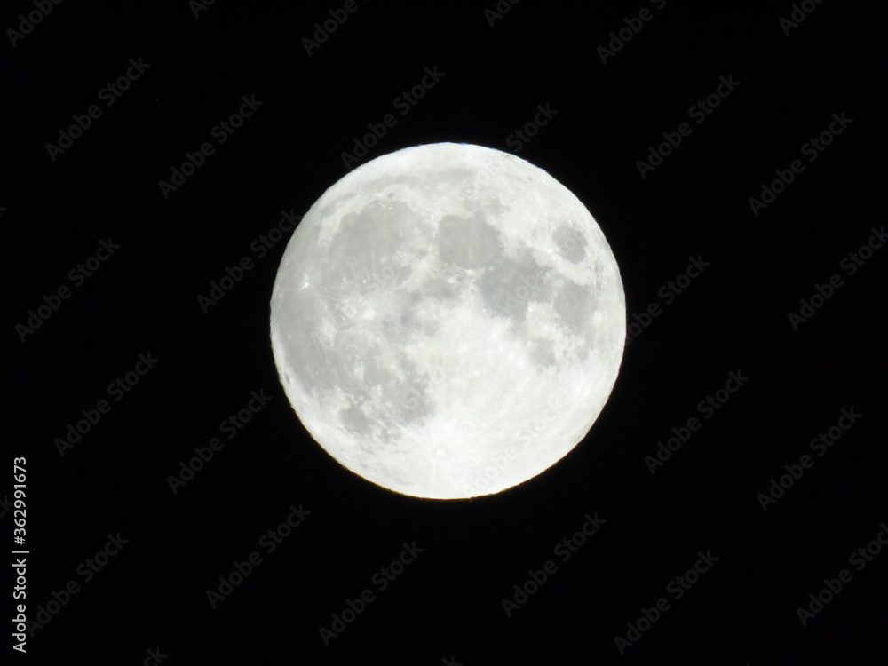 Genova, Italy - 07/05/2020: An amazing photography of the full moon over the city of Genova by night with a great clear and blue sky in the background and some stars. Genova, Italy - 07/05/2020: An amazing photography of the full moon over the city of Genova by night with a great clear and blue sky in the background and some stars.